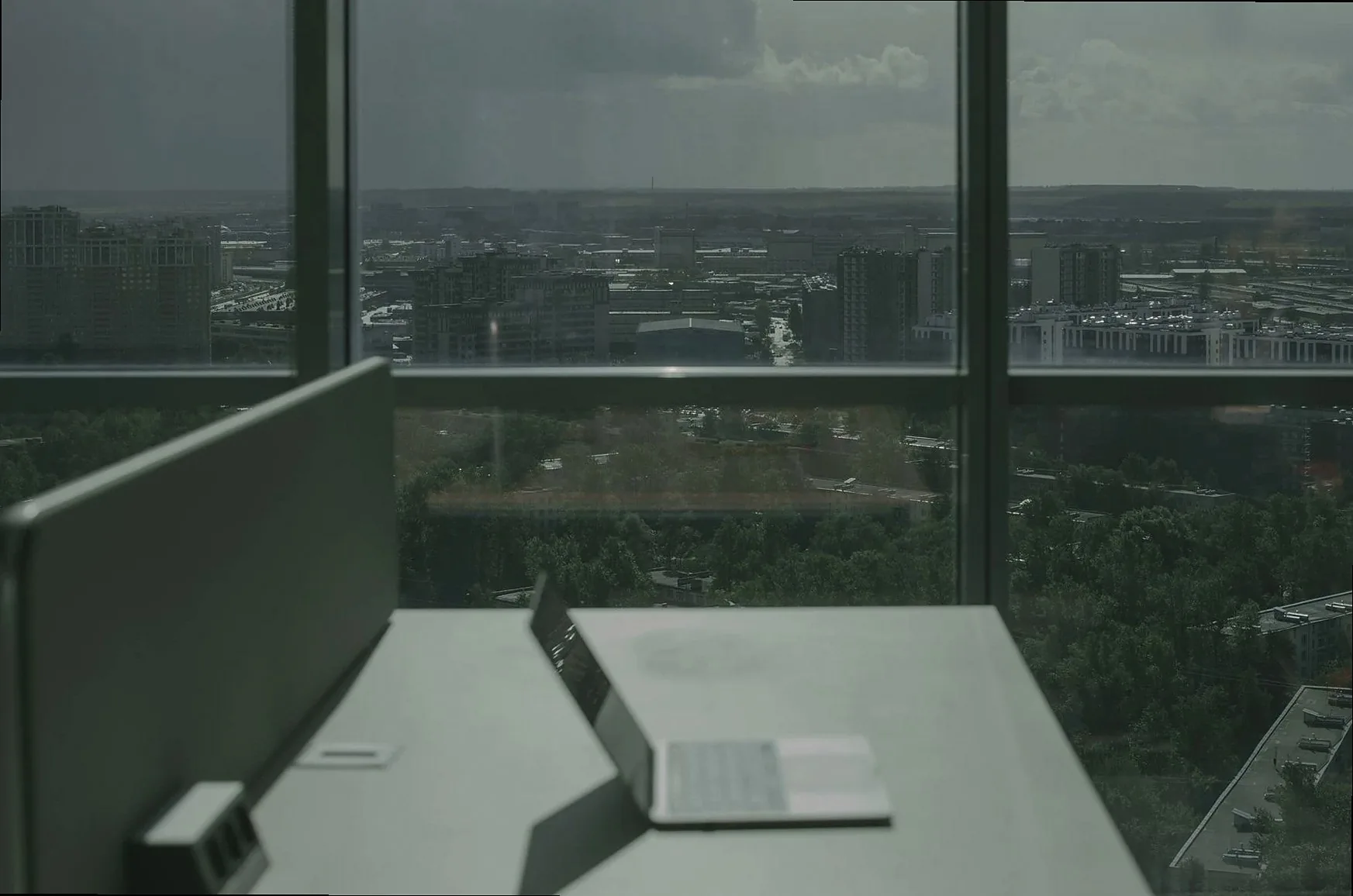 Laptop and handwritten notebook on a wooden desk, natural light, representing careful analytical work